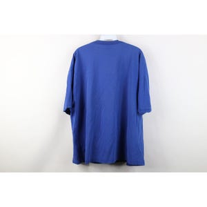 May include: A solid blue t-shirt with short sleeves. The shirt is made of a soft material and hangs on a white hanger against a white background. The shirt is a medium size.
