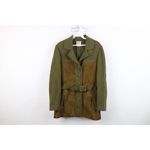 May include: A long-sleeved jacket featuring a combination of olive green fabric and brown suede panels. The jacket includes a notched collar, a central button-down closure with matching buttons, and a matching brown suede belt with a square buckle.