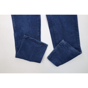 K&ouml;nnte beinhalten: Eine blaue Jeanshose aus Denim. Die Jeans hat ein klassisches F&uuml;nf-Taschen-Design und eine gerade Beinpassform. Der Denim hat eine mittlere Waschung und die Jeans ist am unteren Ende gefaltet.
