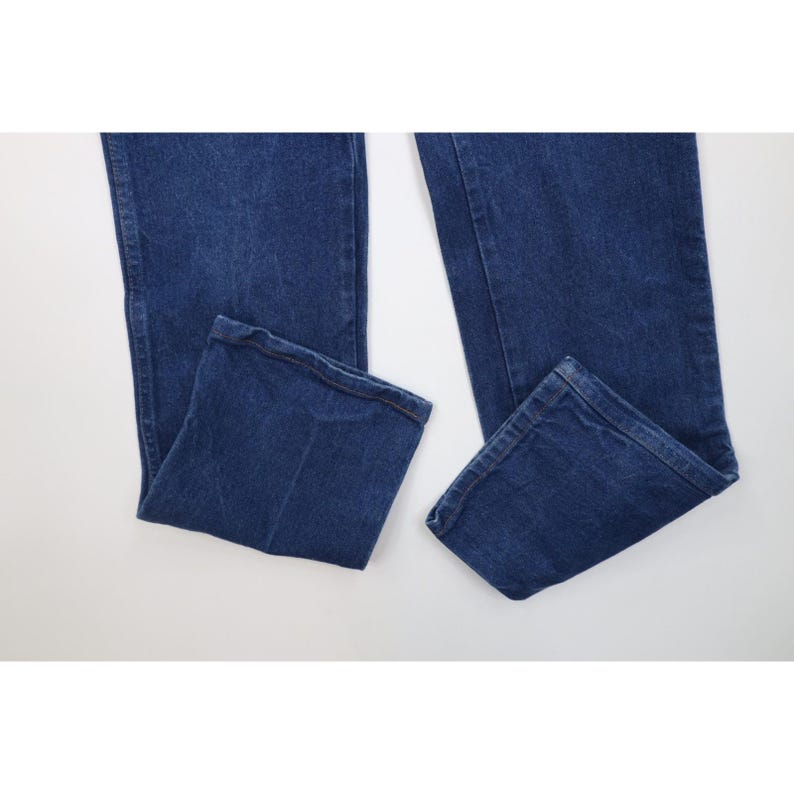 K&ouml;nnte beinhalten: Eine blaue Jeanshose aus Denim. Die Jeans hat ein klassisches F&uuml;nf-Taschen-Design und eine gerade Beinpassform. Der Denim hat eine mittlere Waschung und die Jeans ist am unteren Ende gefaltet.