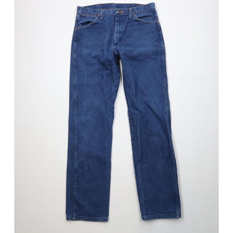 May include: A pair of classic blue denim jeans. The jeans have a traditional five-pocket design, a button and zipper closure, and belt loops. The denim has a slightly faded appearance, suggesting wear.