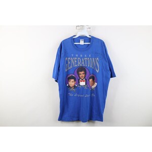 May include: A blue t-shirt with the text "THREE GENERATIONS" above three portraits. The portraits are in purple circles, with signatures below. The text "The Legend Lives On" is below the portraits.