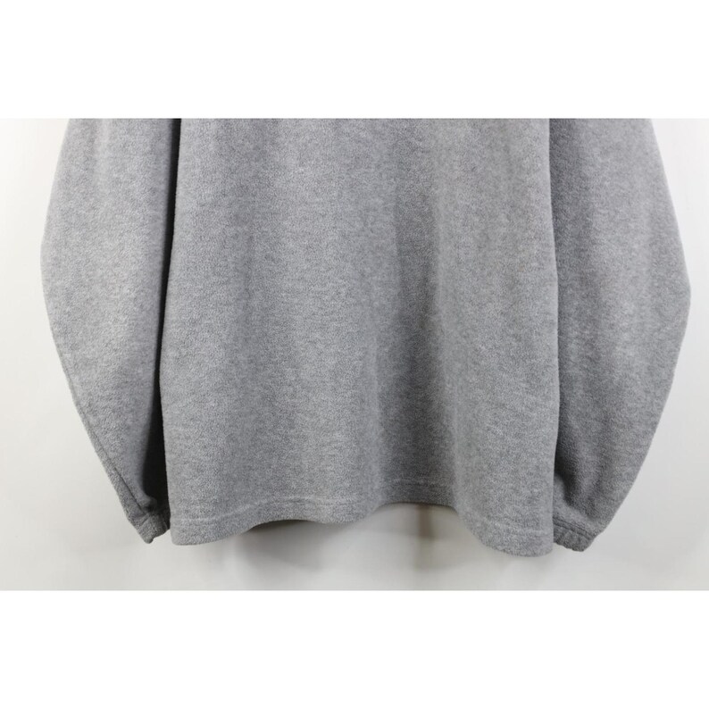 May include: A heather gray sweatshirt with long sleeves. The garment has a crew neck and ribbed cuffs and hem. The fabric appears to be a soft, comfortable material, suitable for casual wear. The sweatshirt is a solid color.