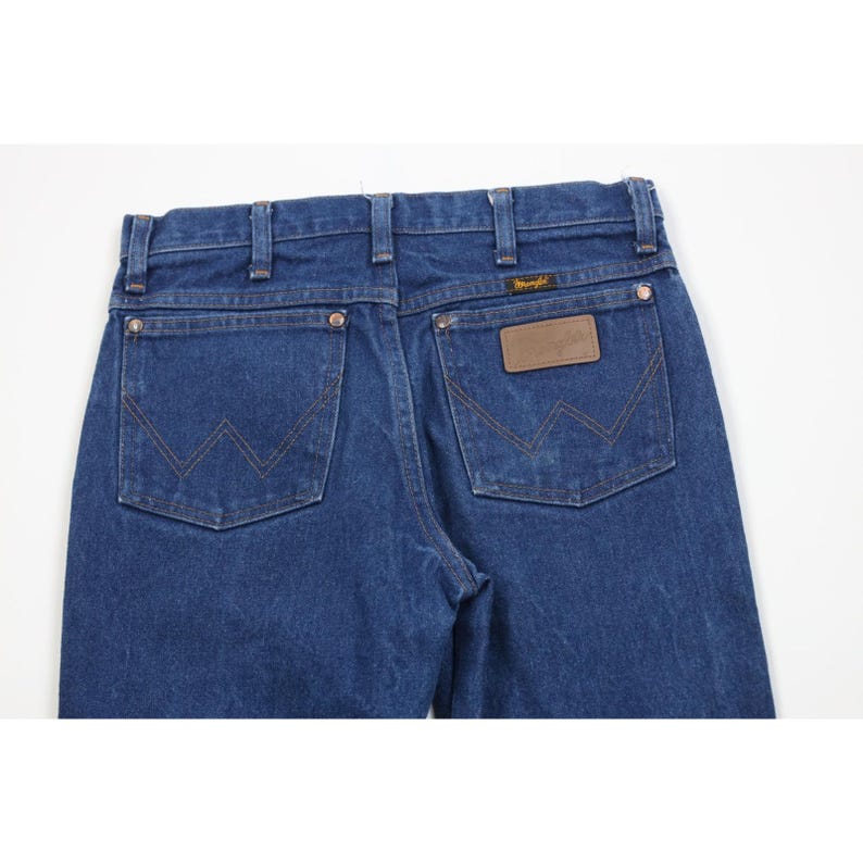 K&ouml;nnte beinhalten: Nahaufnahme der R&uuml;ckseite einer blauen Jeans. Die Jeans hat zwei Ges&auml;&szlig;taschen mit charakteristischen N&auml;hten und einen braunen Lederaufn&auml;her mit dem Markennamen. Die Jeans hat einen klassischen, Vintage-Look.