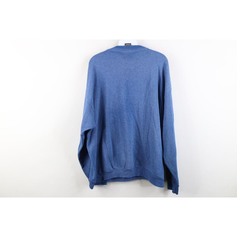 Op de afbeelding: Een effen blauwe sweater met lange mouwen en een ronde hals met een gem&ecirc;leerde textuur. Het kledingstuk is voorzien van een geribbelde kraag, geribbelde boorden aan de uiteinden van de mouwen en een geribbelde zoom aan de onderkant.