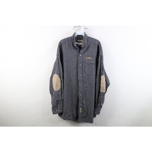 May include: A long-sleeve button-down shirt featuring a navy blue and white micro-check pattern. The shirt includes a single chest pocket with yellow embroidery, a standard collar, and light tan oval-shaped elbow patches on both sleeves.