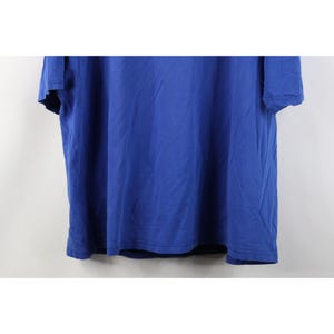 May include: A solid blue t-shirt with short sleeves. The shirt is made of a soft material and has a simple, classic design. The shirt is a vibrant shade of blue and appears to be unworn.