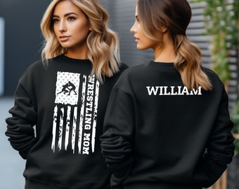 May include: Black sweatshirt with a white distressed American flag design and the text "Wrestling Mom" on the left side. The back of the sweatshirt has the name "William" printed in white.