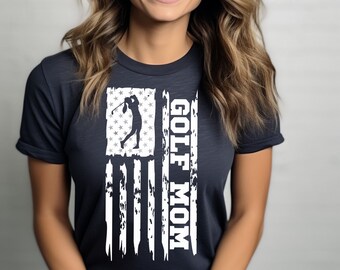 May include: A dark gray t-shirt with a white distressed American flag design. The flag features a silhouette of a golfer and the text "GOLF MOM".
