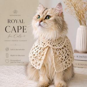 May include: A fluffy cat wearing a handmade, cream-colored crochet cape. The cape has a scalloped edge and is designed for cats. Text on the image reads "ROYAL CAPE for Cats" and "Soft & Breathable".