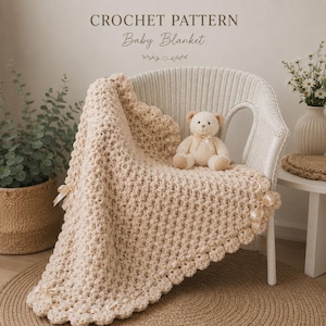 Può includere: Una coperta per neonati all'uncinetto color crema con bordo smerlato e nastri, drappeggiata su una sedia di vimini bianca. Un orsacchiotto è seduto sulla coperta. Il testo "CROCHET PATTERN Baby Blanket" è in alto.
