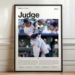 May include: A framed poster featuring a baseball player in action, with the name "Judge" prominently displayed. The poster has a black frame and includes text and statistics. The player is wearing a baseball uniform and swinging a bat.