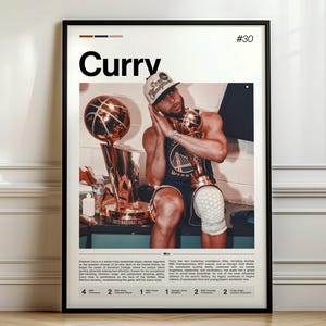 May include: A framed poster featuring the name "Curry" in large white text, with the number "30" in the top right corner. The image shows a basketball player holding trophies. The poster is in a black frame and is displayed against a white wall.