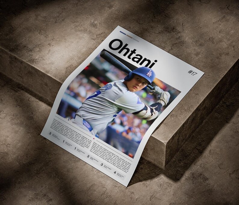 May include: A poster featuring Shohei Ohtani in a Los Angeles Dodgers uniform, swinging a bat. The poster has the name "Ohtani" in large black letters and the number "17". The background is a stadium crowd.