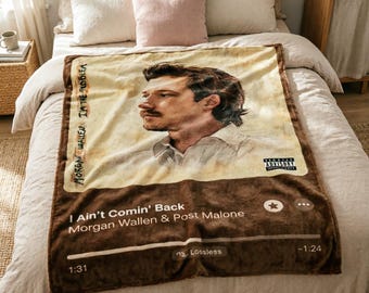 May include: A brown and beige blanket featuring a portrait of a man and the text "I Ain't Comin' Back" by Morgan Wallen & Post Malone. The blanket has a music player interface design with an advisory warning.