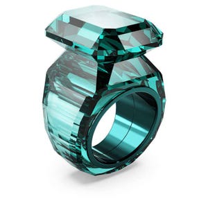 May include: A teal-colored ring with a large, rectangular gemstone. The ring features a faceted design on the band and the gemstone, creating a sparkling effect. The ring is a statement piece, suitable for special occasions.