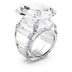 May include: A clear, faceted ring with a large, rectangular gemstone. The ring band is a polished silver color, and the gemstone is clear and sparkling. The ring is designed to catch the light and create a dazzling effect.