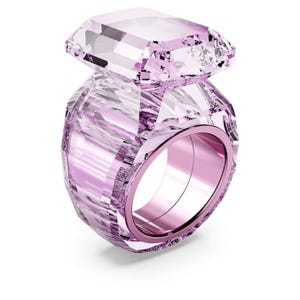 May include: A large, faceted, pink crystal ring. The ring features a large, rectangular-cut crystal stone atop a band with a pink metallic interior. The crystal has a light pink hue and is highly reflective, catching the light.