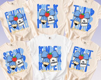 May include: Five off-white t-shirts featuring blue graphic designs for teachers. Each shirt displays a blue gingham bow, a red apple, a pencil, and a white tag labeled Ms. Johnson. The text includes grade levels like Pre-K, First, Second, Third, and Fourth.