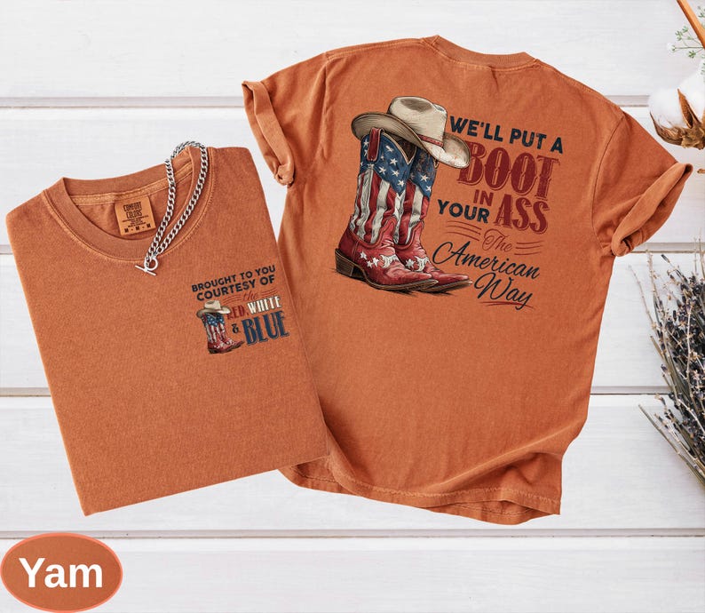 May include: Two orange-colored t-shirts. One shirt features a graphic of a cowboy boot with the American flag design and the text "BROUGHT TO YOU COURTESY OF RED, WHITE & BLUE". The other shirt has a cowboy boot with the American flag design and the text "WE'LL PUT A BOOT IN YOUR ASS The American Way".