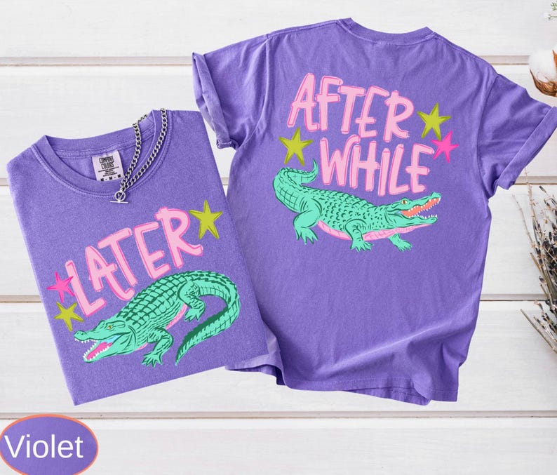 Front and back graphic placements. The front showcases a green gator illustration below bold pink text reading "LATER". The back mirrors this layout with a green crocodile beneath the phrase "AFTER WHILE". Both sides are embellished with yellow and pink stars.