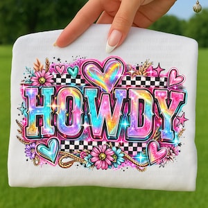 May include: A white t-shirt featuring the word "HOWDY" in a vibrant, rainbow-colored font. The design includes hearts, flowers, stars, and a checkered pattern, creating a colorful and cheerful aesthetic.
