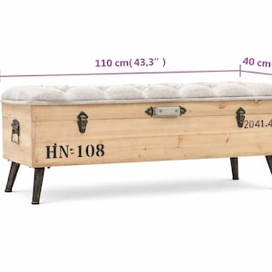 May include: A wooden storage bench with a tufted, light gray upholstered top. The bench is 43.3 inches long, 15.7 inches wide, and 19.7 inches high. It features metal hardware, black legs, and the text "HN=108" and "2041.4" printed on the front.
