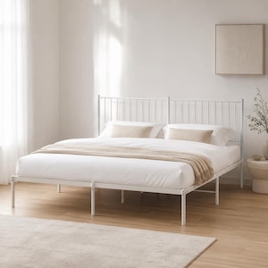 May include: A white metal bed frame featuring a tall headboard with vertical slats. The bed is dressed with white bedding, two beige rectangular pillows, and a beige throw blanket draped across the foot of the mattress.