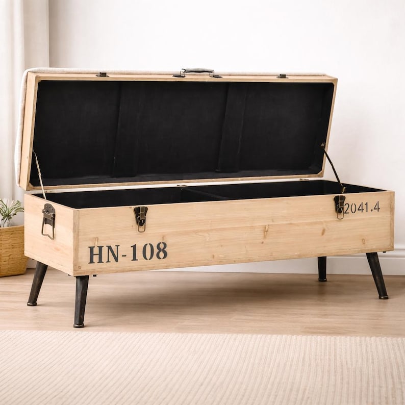 May include: A light-colored wooden storage bench with a hinged lid, open to reveal a black interior. The bench has black metal legs and hardware, with the text "HN-108" printed on the front. The bench is 50 inches long.