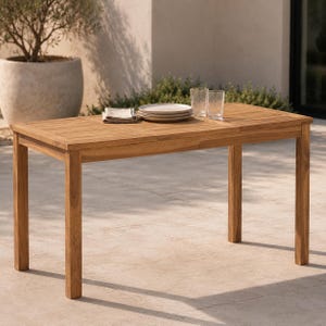 May include: A rectangular outdoor dining table crafted from light brown wood with a slatted surface design. The table features four straight legs and is set with a stack of white plates, a folded beige napkin, and two clear drinking glasses.