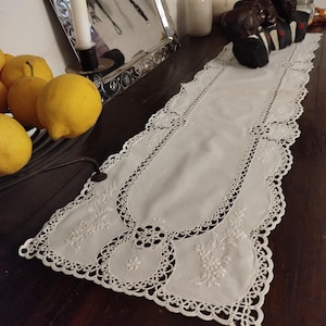 Puede incluir: Un juego de tres tazas de cerámica con un esmalte moteado de color crema. Cada taza presenta un diseño pintado a mano diferente: una hoja azul y verde, una flor amarilla y naranja y una baya roja. Las tazas tienen una forma simple y redondeada.