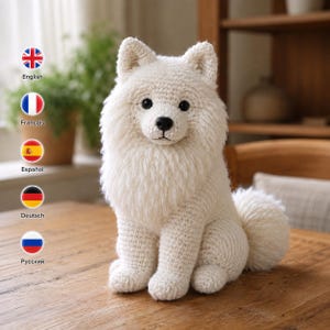 May include: A white crocheted stuffed animal shaped like a fluffy dog with pointed ears, a black nose, and dark eyes. The toy features a thick, textured mane around the neck and a curled tail, sitting upright on a wooden surface.