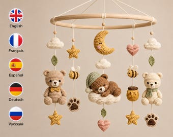 May include: A nursery mobile featuring a circular wooden frame with hanging crochet elements including two teddy bears, a sleeping bear on a cloud, a yellow crescent moon, stars, hearts, bees, honey pots, paw prints, and green leaves.