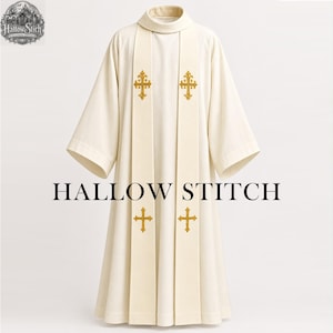 Op de afbeelding: Een gebroken wit liturgisch albe met een hoge kraag en wijde mouwen. Twee verticale banen lopen over de voorzijde, elk geborduurd met twee goudkleurige, sierlijke kruismotieven. De tekst HALLOW STITCH staat in het midden van het kledingstuk.