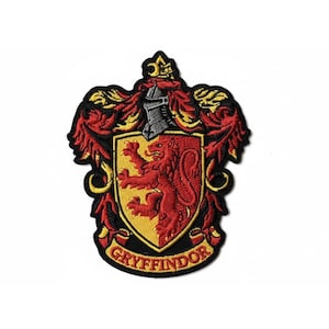 Peut inclure: Écusson brodé représentant le blason de la maison Gryffondor de la série Harry Potter. Le blason comprend un lion rouge sur un écu jaune, entouré d'ornements rouges et dorés, avec le mot "Gryffondor" en bas.