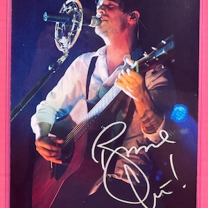 May include: A white ceramic mug with a black handle and the text "But First, Coffee" in a bold, black font. The mug is set against a neutral background, highlighting its simple design.