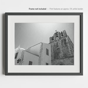 May include: Black and white photograph of a church building with a bell tower. The image is framed in a black border with a white mat. The text "Frame not included - Print features an approx. 5% white border" is at the top.