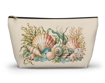 May include: A beige zippered pouch featuring a printed illustration of various seashells, including a large fan shell, a spiral conch, and a sand dollar, interspersed with green seaweed, coral, and smooth blue sea glass pieces.