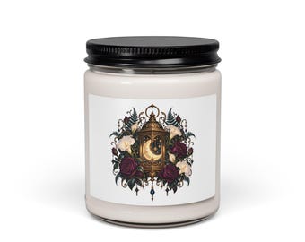 Puede incluir: Un frasco de vela de vidrio transparente con tapa negra y cera blanca. La etiqueta presenta una ilustración de una linterna dorada con una luna creciente en su interior, rodeada de rosas rojo oscuro, flores blancas y helechos verdes.