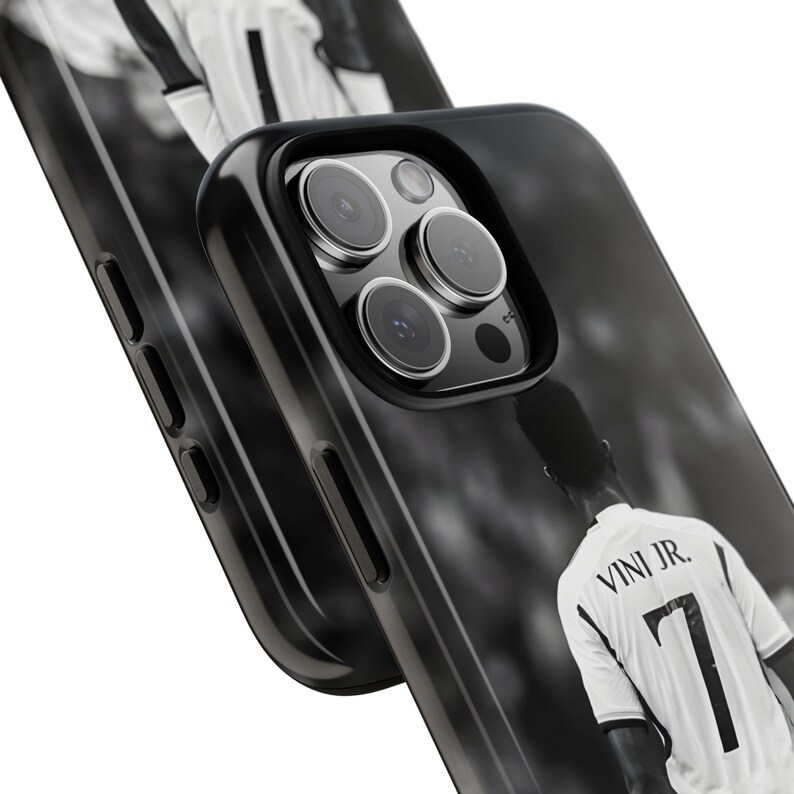 May include: A black smartphone case featuring a black and white graphic of a soccer player wearing a jersey with the text VINI JR. and the number 7 on the back. The case has a cutout for a triple-lens camera system and side buttons.