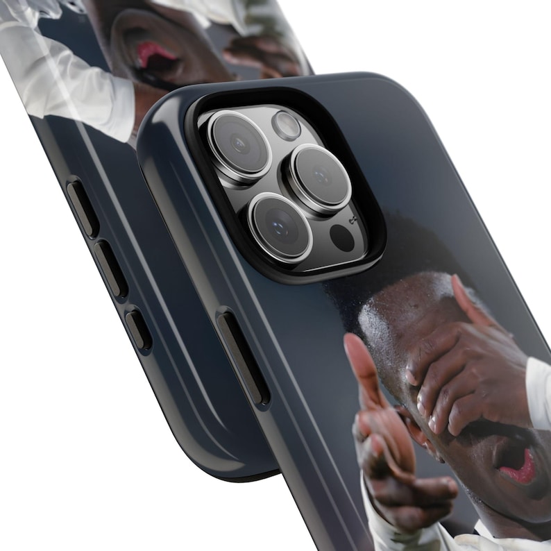 May include: A dark blue smartphone case featuring a printed graphic of a person with their hands covering their face and mouth. The case has a cutout for a triple-lens camera system and black side buttons. The design wraps around the edges of the case.