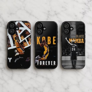 May include: Three black phone cases featuring basketball imagery. The left case shows a collage of a player in a yellow jersey. The center case displays a player jumping with the text KOBE FOREVER. The right case shows a player from behind with the text BLACK MAMBA.