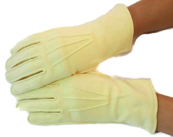 Pode incluir: Um par de luvas de cor amarelo claro com um design simples. As luvas são feitas de um tecido macio e liso.