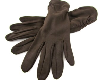 Könnte beinhalten: Ein Paar braune Handschuhe aus weichem, dehnbarem Stoff. Die Handschuhe sind in der Hälfte gefaltet, wobei die Fingerspitzen eines Handschuhs in die Handfläche des anderen gesteckt sind.