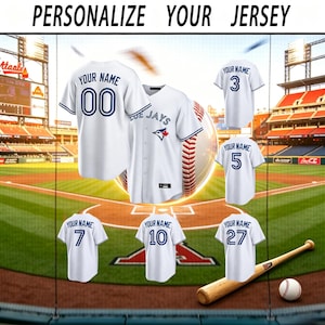 Puede incluir: Camisetas de béisbol blancas con detalles azules y texto personalizado. La imagen muestra varias camisetas con diferentes números y el texto "YOUR NAME". También se ven un bate y una pelota de béisbol. El texto "PERSONALIZE YOUR JERSEY" está en la parte superior.
