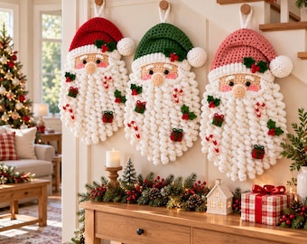 May include: Three crocheted Santa Claus wall hangings featuring white textured beards, red, green, and pink hats with white pom-poms, and small decorative accents including candy canes, green presents, and holly leaves attached to the beards.