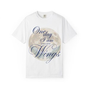 Pode incluir: Uma caneca de cerâmica branca com uma alça preta e o texto "But First, Coffee" em negrito preto. A caneca está sobre uma superfície de madeira. A caneca tem 10 cm de altura.