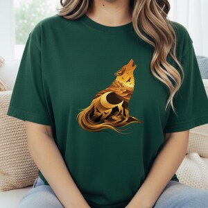 A woman wearing a dark forest green t-shirt that provides a rich, deep background for the glowing golden sun and desert mountains within the wolf.