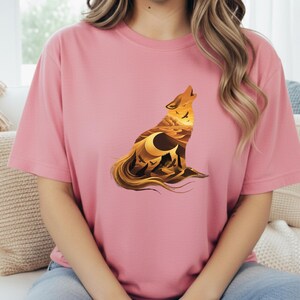 A woman wearing a soft pink t-shirt showcasing the high-contrast desert silhouette in shades of amber and black.