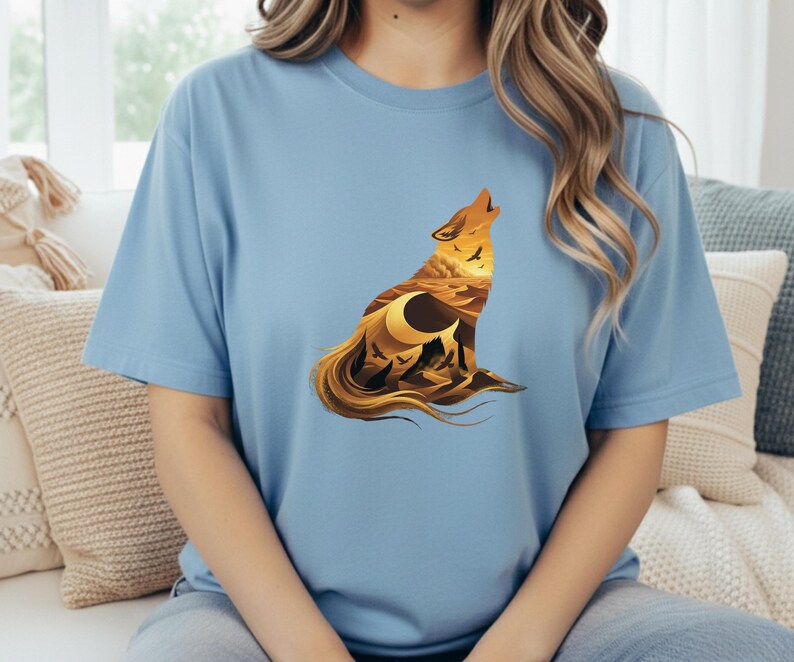 A woman in a light blue t-shirt with the desert wolf silhouette, offering a bright and airy contrast to the warm orange tones of the print.
